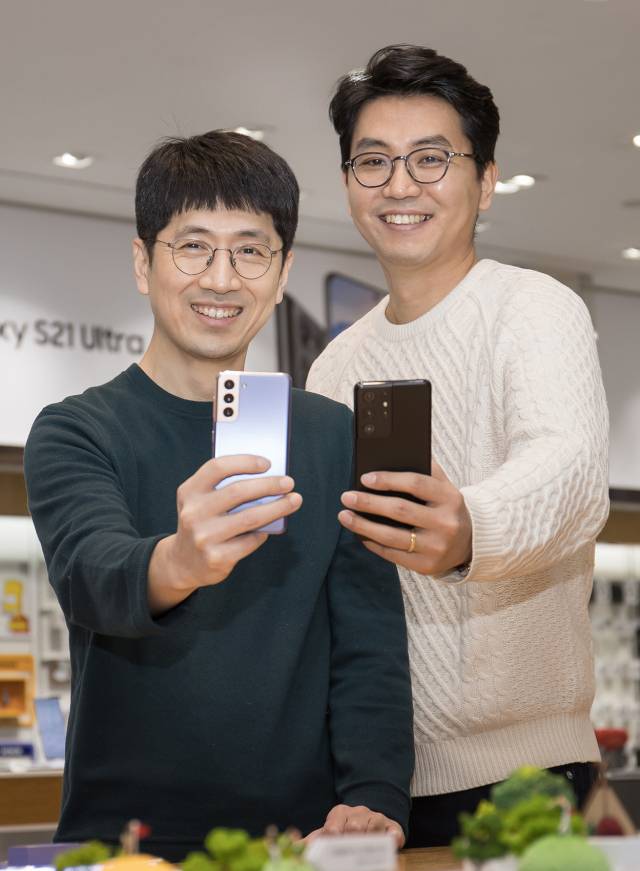 최지환(왼쪽)·여동원 삼성전자 비주얼소프트웨어 그룹 소속 프로가 갤럭시S21 카메라를 들어 보이고 있다. /삼성전자