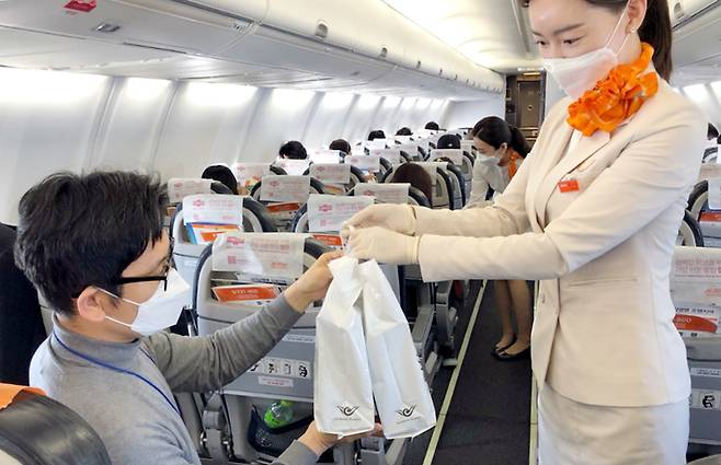 제주항공이 지난해 12월 12일 일본 상공을 비행하고 돌아오는 무착륙 국제 관광비행을 실시했다. 이날 한 탑승객이 기내에서 면세품을 사고 있다.[연합]