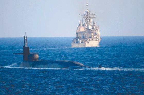 미국의 오하이오급 핵잠수함 조지아호( 왼쪽)와 순양함 포트 로열호 가 페르시아만의 원유 수송로인 호르무즈 해협을 항해하는 사진이 지난해 12월 21일(현지시간) 공개됐다. [AP=연합뉴스]