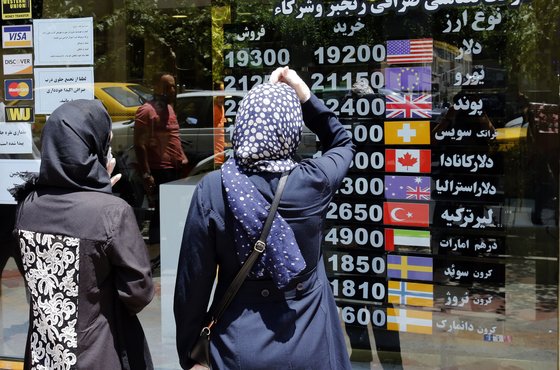 이란 화페 가치가 미국의 제재와 코로나19의 영향으로 사상 최저 수준을 기록했다. 사진은 지난해 6월 22일 이란 테헤란에서 환율을 살펴보고 있는 이란 여성들. [EPA=연합뉴스]