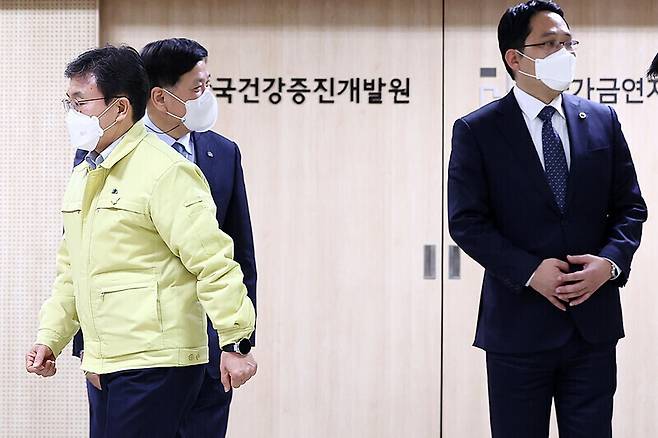 Minister of Health and Welfare Kwon Deok-cheol (left) returns to his seat after a photo op at a second meeting of the joint physician-government COVID-19 vaccination committee, which was held at the Korea Health Promotion Institute on Feb. 21. Choi Dae-zip, president of the Korean Medical Association, is seen on the right. (Yonhap News)