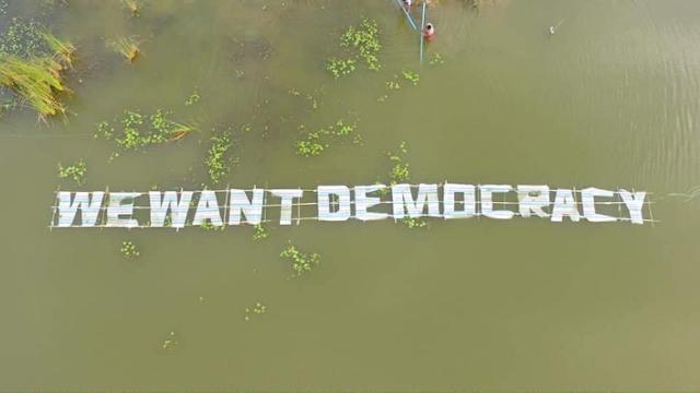 미얀마의 한 시민이 21일 강 위로 '민주주의를 원한다'는 대형 구호를 만들어 띄우고 있다. SNS 캡처