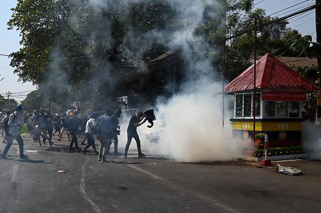 28일 미얀마 최대도시 양곤에서 최루가스를 쏘는 경찰에 맞서 시민들이 군부 퇴진을 요구하는 가두 시위를 벌이고 있다.  /AFP 연합뉴스