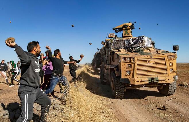 2019년 11월 8일 시리아의 쿠르드족이 터키 시리아 국경지역에서 러시아군과 함께 순찰하던 터키 군용차량에 돌을 던지고 있다. AFP=연합뉴스