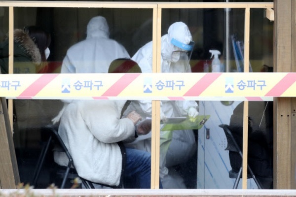 지난달 25일 서울 송파구보건소 선별진료소에서 코로나19 검사를 받으려는 시민들이 문진표를 작성하고 있다. 뉴스1
