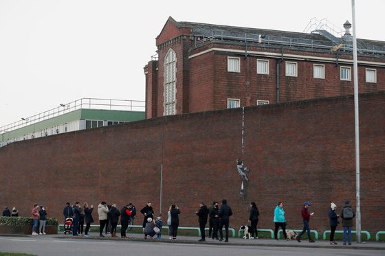 현지시각 1일, 영국 버크셔 레딩 감옥(HM Prison Reading) 인근 주민들이 벽화를 감상하고 있다. 〈사진=로이터〉
