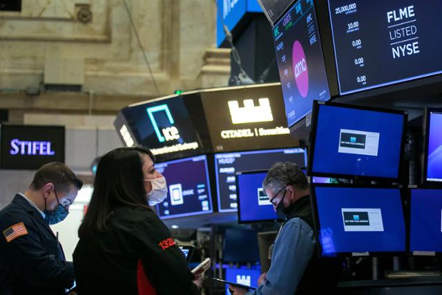 지난달 25일(현지시간) 미국 뉴욕증권거래소(NYSE)에서 트레이더들이 업무를 하고 있다. 이날 뉴욕증시의 3대 주요 지수는 국채 금리가 치솟자 급락세로 마감했다. 연합뉴스