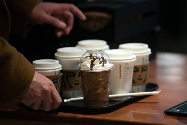 지난달 16일 서울 시내의 한 커피전문점에서 고객이 일회용컵에 담긴 커피를 받아들고 있다. 뉴스1