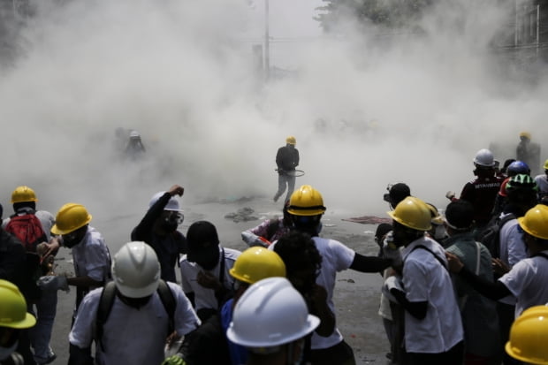 미얀마 최대 도시 양곤에서 2일(현지시간) 군부 쿠데타 규탄 시위대가 군경이 쏜 최루 가스를 피해 뒤로 물러나고 있다./ 사진=EPA
