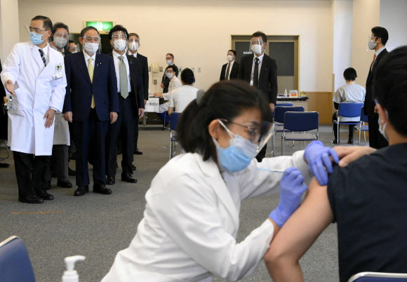 코로나19 백신 접종 현장 찾은 스가 일본 총리 - 스가 요시히데(위 왼쪽 2번째) 일본 총리가 18일 도쿄에 있는 국영 도쿄 메디컬 센터에서 신종 코로나바이러스 감염증(코로나19) 백신 접종 모습을 지켜보고 있다, 일본은 전날 화이자 백신으로 코로나19 예방접종을 시작했다. 사진=AFP 연합뉴스