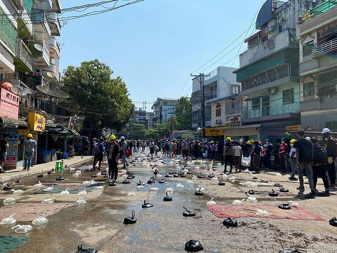 최루탄을 대비해 시위대가 도로 위에 놓아둔 물이 담긴 비닐봉지.2021.3.4 [프런티어 미얀마 캡처. 재판매 및 DB 금지]