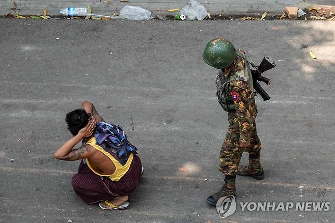 미얀마군에 연행된 군부 쿠데타 규탄 시위대 (만달레이 AFP=연합뉴스) 미얀마 제2의 도시 만달레이에서 3일(현지시간) 연행된 군부 쿠데타 규탄 시위 참가자 곁에 총을 멘 군인이 서 있다. AP통신은 이날 전국에서 대규모 시위가 벌어졌으며 쿠데타 발발 이후 가장 많은 33명의 시위대가 군경의 총격에 숨졌다고 전했다. sungok@yna.co.kr