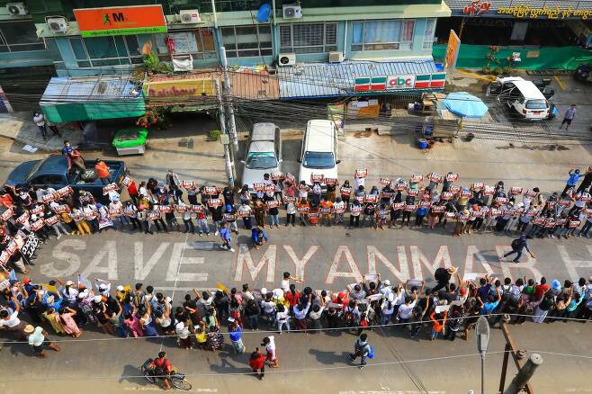 군부 쿠데타에 저항하고 있는 미얀마 시민들이 27일 수고 양곤의 도로에 미얀마를 구해달라는 글씨를 새겨 국제사회의 도움을 요청하고 있다. AFP=연합뉴스