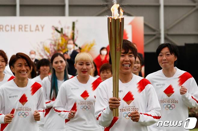 일본 여자 축구 대표 선수들이 2021년 3월25일 (현지시간) 후쿠시마현 나라하에서 도쿄 올림픽 성화 봉송 첫 주자로 뛰고 있다. © AFP=뉴스1 © News1 우동명 기자
