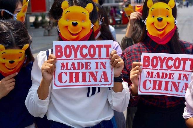 시진핑 중국 주석을 풍자하는 '곰돌이 푸' 캐릭터 가면을 쓰고 '중국산제품 보이콧' 포스터를 든 만달레이 시위대 2021.4.6    [@SweZinWin87 트위터 캡처. 재판매 및  DB 금지]