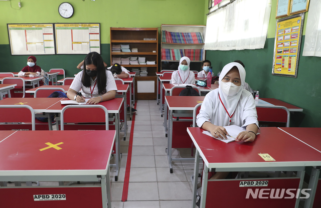 [브카시=AP/뉴시스]23일(현지시간) 인도네시아 자카르타 외곽 브카시의 한 학교 교실에 학생들이 코로나19 확산 방지를 위해 사회적 거리를 두고 앉아 있다. 2021.03.23.