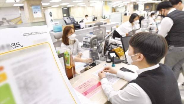 금융사의 소비자 보호와 설명 의무를 대폭 강화한 금융소비자보호법이 지난달 25일 시행되면서 투자상품 가입 절차가 복잡해졌다는 불만이 잇따르고 있다. 한 소비자가 8일 서울 여의도 시중은행 창구에서 펀드 가입 상담을 하고 있다. 김범준 기자 bjk07@hankyung.com