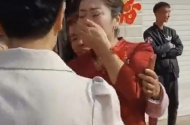 중국의 한 결혼식에서 며느리가 알고 보니 친딸인 믿기 힘든 일이 벌어졌다. 사실을 알고 눈물을 흘리는 신부의 모습. QQ.com 캡처
