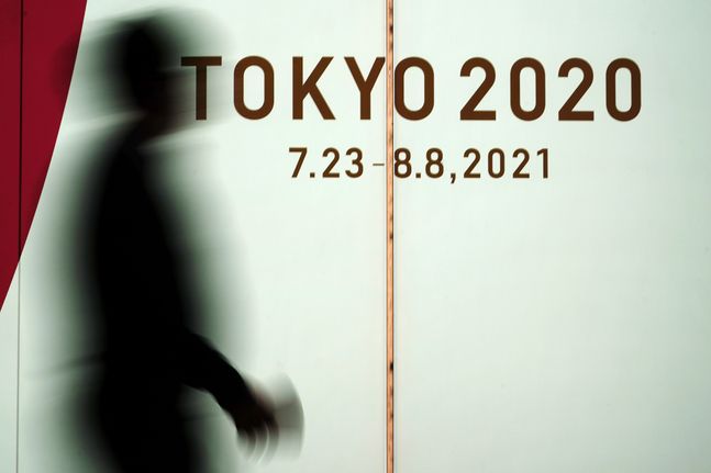 17일 일본 도쿄에서 코로나19 확산을 막기 위해 마스크를 쓴 한 남성이 2020 도쿄 올림픽 광고판 앞을 지나고 있다. ⓒAP/뉴시스