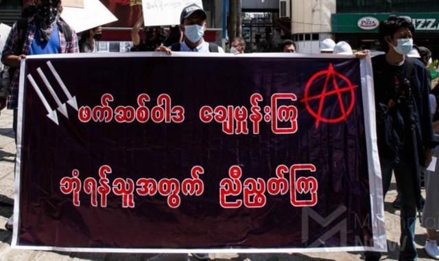 지난달 미얀마 양곤에서 반군부 시위대가 "공동의 적에 맞서 단결하자"는 현수막을 들고 거리 행진을 하고 있다. 미얀마 나우 캡처