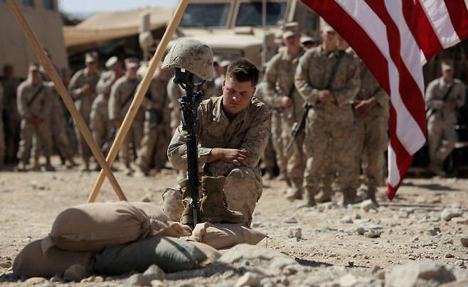 미 해병대원들이 아프간 남부 헬만드주에서 탈레반과 교전 도중 전사한 동료를 추모하고 있다. AP·연합뉴스