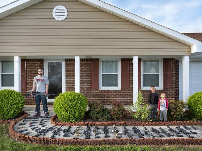 브랜든 브라운이 미국 앨라배마주 하베스트에 있는 집 앞에서 자녀 애쉬 탄(5), 카슨(3)과 함께 포즈를 취하고 있다. 브라운은 12살때 처음으로 총을 쏘았다. 18살때는 AK-47 소총을 구입했다. 사진제공= World Press Photo