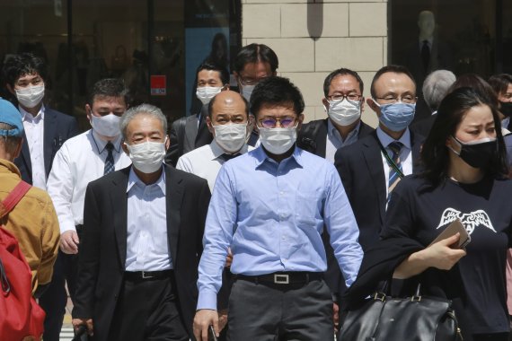 20일 도쿄에서 마스크를 쓴 사람들이 길을 건너고 있다. AP뉴시스