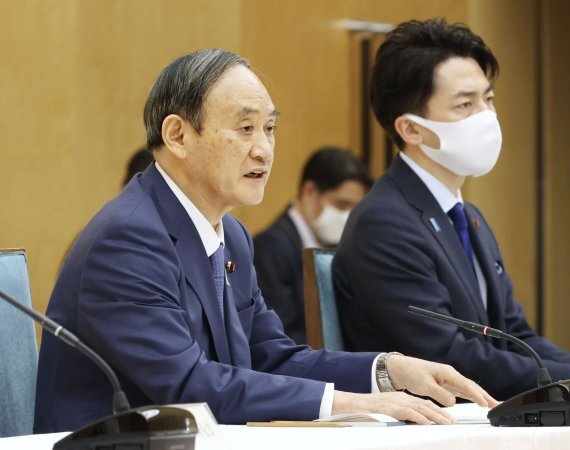 스가 요시히데 일본 총리(왼쪽)가 22일 도쿄 총리실에서 화상으로 열린 세계 기후 정상회의에 참석하고 있다. 스가 총리는 이날 2013년 대비 2030년까지 온실가스 배출량을 46% 감축하고 2050년까지 탄소 중립을 달성하겠다고 밝혔다. AP뉴시스