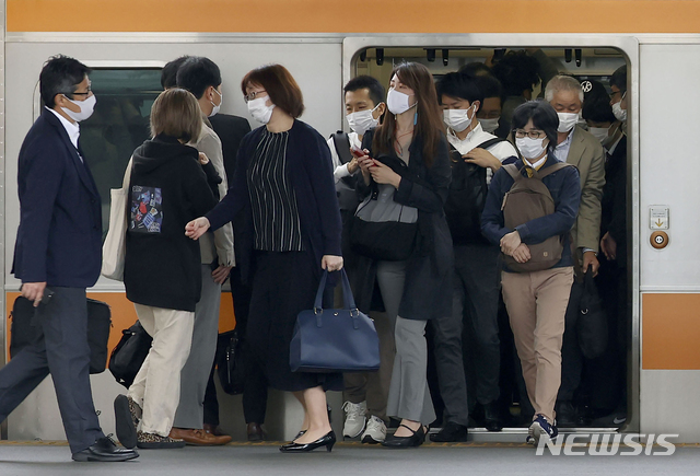 [도쿄=AP/뉴시스]6일 일본  수도 도쿄의 지하철역에서  코로나19 예방을 위해 마스크를 착용한 통근자들이 서둘러 내리고 있다. 2021.05.06.