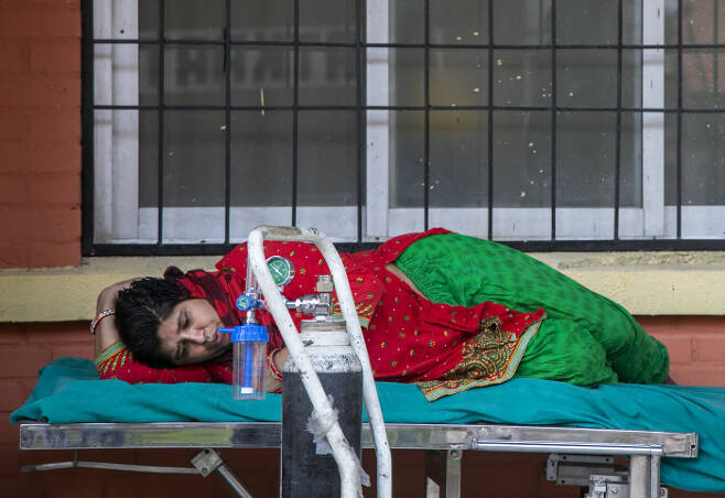 네팔 수도 카트만두의 한 병원 응급 병동 앞에서 코로나19 환자가 6일(현지시간) 의료용 산소를 공급받기 위해 기다리고 있다. 카트만두｜AP연합뉴스