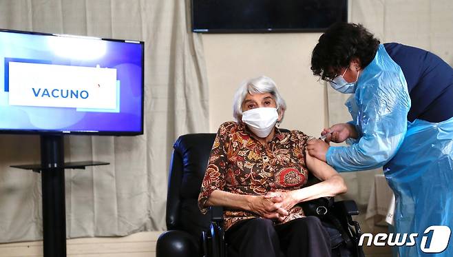 칠레 라세레나 노인요양원에서 2021년 1월 18일 라우라 아레유나(79)씨가 화이자 백신을 접종받고 있다. © 로이터=뉴스1 © News1 최서윤 기자