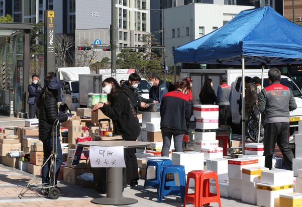 지난 14일 서울 강동구 고덕동의 한 아파트 단지 입구에서 시민들이 택배를 찾고 있다.