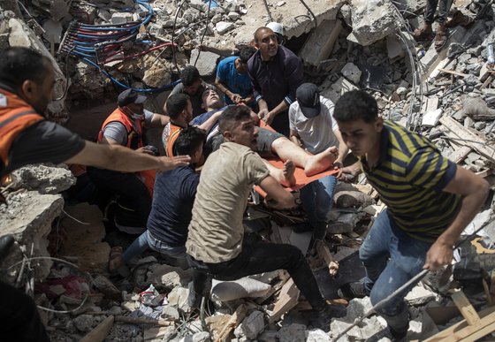 16일 이스라엘의 공습으로 붕괴된 팔레스타인 가자지구 내 주택 건물 잔해 밑에서 생존자를 구출하고 있다. [AP=연합뉴스]