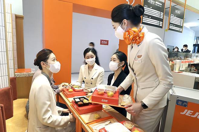 AK& 홍대점에서 오는 7월까지 운영하는 기내식 카페 ‘여행의 행복을 맛보다’에서 제주항공 승무원들이 제품을 판매하고 있다. /AK플라자 제공