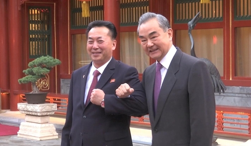 팔짱 낀 왕이 중국 외교부장(오른쪽)과 리룡남 북한 대사. 봉황위성TV 캡처
