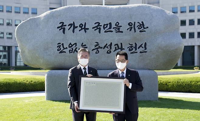 문재인 대통령이 4일 오후 국가정보원에서 새로운 국정원 원훈석을 제막한 뒤 기념촬영하고 있다. 국정원 원훈은 5년 만에 '국가와 국민을 위한 한없는 충성과 헌신'으로 교체됐다. /청와대 제공