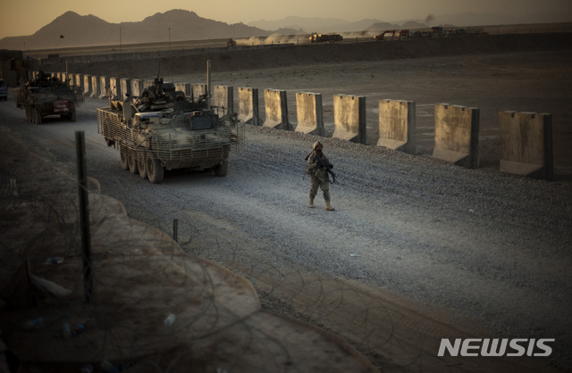 [AP/뉴시스] 2009년 8월 자료사진으로 아프간에서 병사와 장갑차량이 남동부 칸다하르 인근 군기지로  향하고 있다