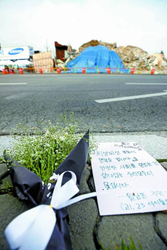 13일 광주 철거건물 붕괴사고 현장 인근에 꽃다발과 손편지가 놓여있다. 이날까지 희생자 9명 중 7명의 발인이 이뤄졌고, 오늘(14일) 마지막 2명의 발인이 진행된다. [연합뉴스]