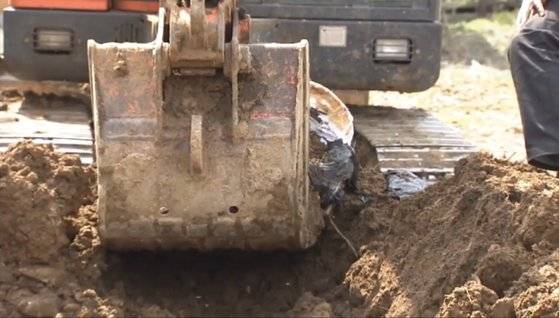 2011년 4월 김제 마늘밭에서 경찰이 굴착기를 이용해 밭 주인 부부가 숨겨둔 돈을 찾고 있다. 중앙포토