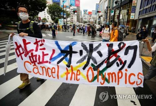 (도쿄 로이터=연합뉴스) 19일 일본 도쿄도(東京都)에서 올림픽 취소를 요구하는 시민이 횡단막을 들고 시위를 하고 있다.