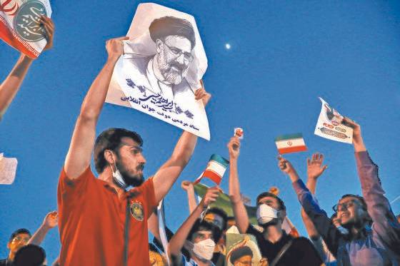 라이시 대통령 당선인의 지지자들이 그의 사진과 이란 국기 등을 들어 올리며 승리를 축하하는 장면. 그는 이날 대선에서 61.9%의 득표율로 당선됐다. [AP=연합뉴스]