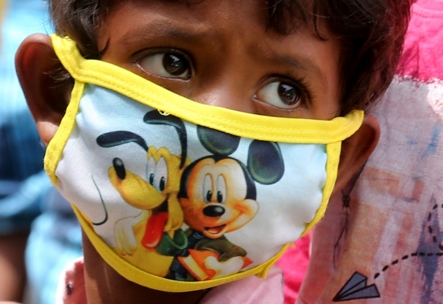 마스크를 쓴 인도의 한 소년이 불안한 눈빛으로 무언가를 쳐다보고 있다. EPA연합뉴스