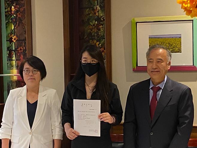 에리아나 민지 리가 22일(현지시간) 미국 버지니아주 아난데일의 한 음식점에서 헌법소원 접수증을 들고 있다. 리의 좌우는 각각 헌법소원에 관여한 임국희 미국 변호사와 전종준 미국 변호사.