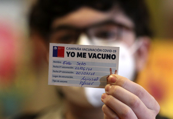22일(현지시간) 칠레 산티아고에 있는 만성질환 아동 치료 전문 병원에서 에두 소토(15)라는 소년이 백신 접종 카드를 보여주고 있다. 뉴시스