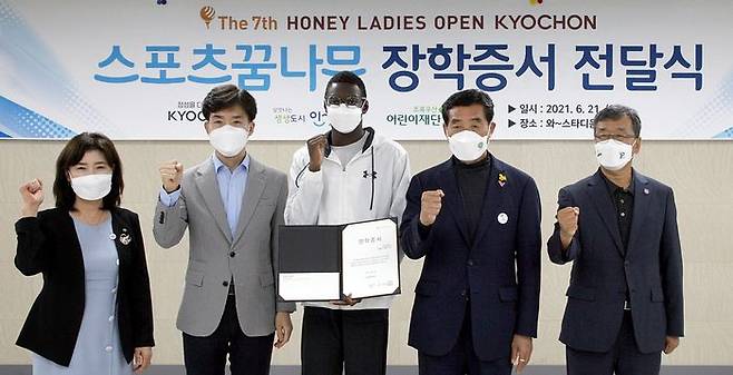 교촌치킨을 운영하는 교촌에프앤비㈜가 지난 21일(월) 경기도 안산 와스타디움에서 안산시 스포츠 유망주를 위한 장학금 전달식을 진행했다. 이날 행사에 참석한 참석자들이 수혜자 대표인 육상 유망주 ‘비웨사 다니엘 가사마’와 기념사진 촬영을 하고 있다. (왼쪽부터) 김창연 초록우산어린이재단 경기지역본부장, 임형욱 교촌에프앤비 대외협력부문장, 비웨사 다니엘 가사마, 윤화섭 안산시장, 배정완 안산시체육회 회장 (사진제공=교촌에프앤비(주))