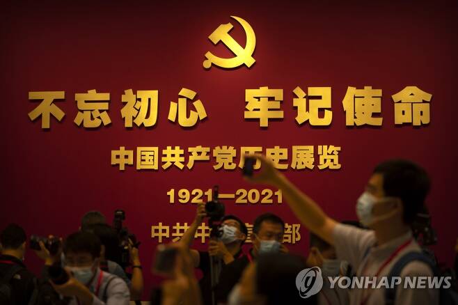 25일 중국 베이징의 중국 공산당 역사박물관에 있는 창당 100주년 기념 문구 앞에서 시민들이 사진을 찍고 있다.[AP=연합뉴스]