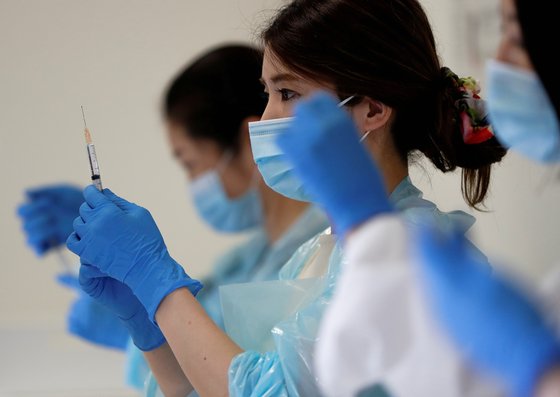 지난 12일 일본 고베시의 코로나 백신 접종회장에서 의료진이 접종 준비를 하고 있다. [로이터=연합뉴스]