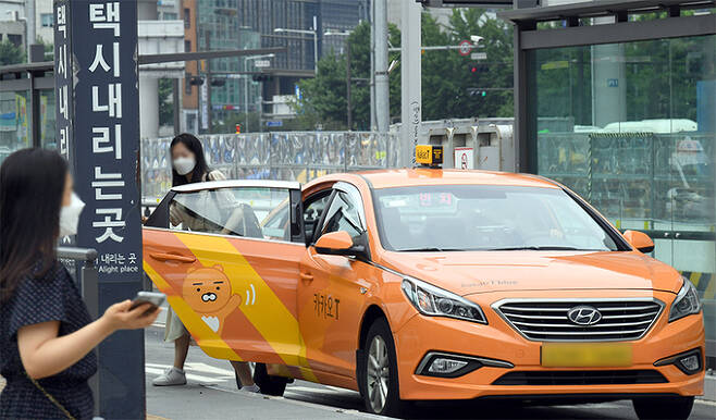 11일 서울역 택시 승강장에서 한 승객이 카카오택시에서 내리고 있다. 이날 카카오모빌리티에 따르면, 오는 22일부터 카카오택시의 유료 요금제에 새로운 약관이 적용되면서 택시기사의 평점이 낮으면 배차 혜택을 받지 못하게 될 전망이다. 남정탁 기자