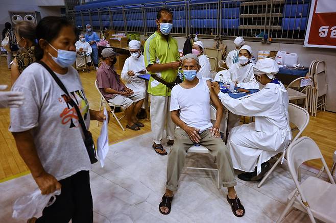 6월 29일(현지시각) 태국 푸껫의 한 경기장에서 의료진이 고령 주민들을 대상으로 아스트라제네카의 코로나바이러스 감염증(코로나) 백신을 접종하고 있다. / AFP연합뉴스