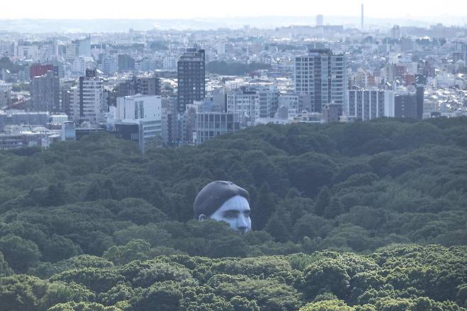 공공미술 열기구 ‘마사유메’(正夢)가 16일 일본 도쿄 요요기공원 나무숲 사이로 떠오르고 있다. AFP=연합뉴스